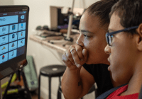 Mom and teenage son look at adaptive computer screen