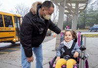 child in wheelchair with teacher's aide