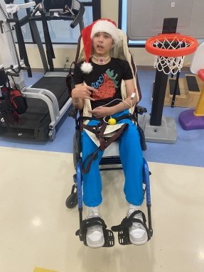 Photo of teenager wearing a santa hat in a wheelchair