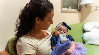 Therapist feeding baby with bottle