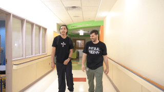 Patient walking down the hallway with physical therapist