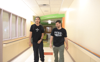 Patient walking down the hallway with physical therapist