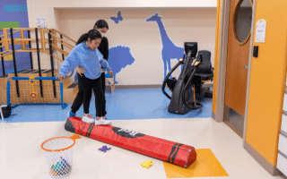 child and therapist working on balance on a balance beam