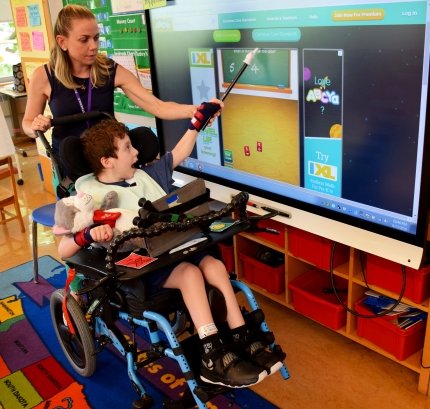 child in school pointing