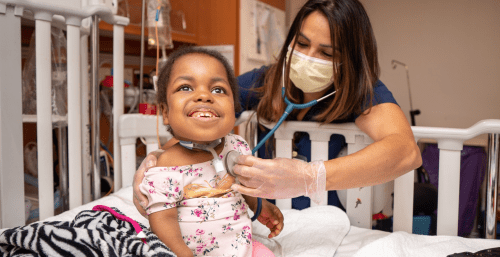 therapist examining child in crib